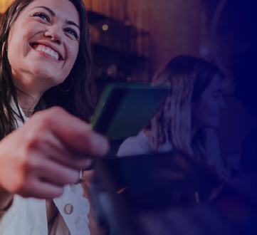mulher feliz aproximando carto de mquina para pagamento