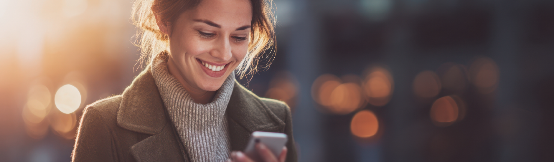 mulher com roupas de inverno sorrindo mexendo em celular