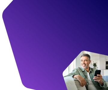 Foto de homem sentado confortavelmente, segurando seu celular em uma das m�os e sorrindo enquanto olha para o horizonte.